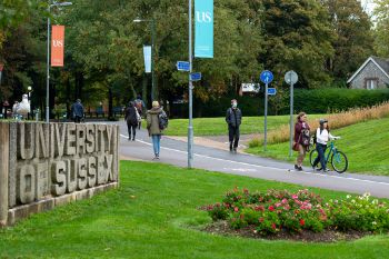 People walking by Sussex sign