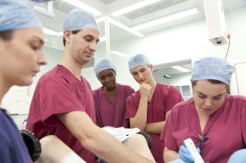Students in theatre wearing scrubs