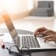Hands typing on a laptop keyboard.