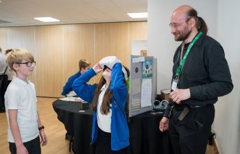 Two students using virtual reality headsets with Dr Daniel Creed during MidSussex Science Week