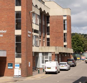 red brick building alongside Refectory Road, with a bus stop